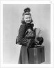 Smiling young blond woman wearing hat fur trimmed coat carrying packages by Anonymous