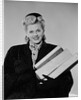 Blond woman smiling wearing winter coat carrying shopping parcel by Anonymous