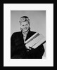 Blond woman smiling wearing winter coat carrying shopping parcel by Anonymous