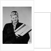Blond woman smiling wearing winter coat carrying shopping parcel by Anonymous