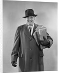 Smiling man carrying shopping boxes wearing hat coat gloves by Anonymous