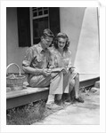 Man woman sitting on porch of farmhouse reading catalog by Anonymous