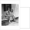 Man woman sitting on porch of farmhouse reading catalog by Anonymous