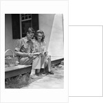 Man woman sitting on porch of farmhouse reading catalog by Anonymous