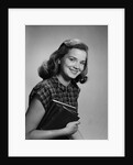 Young smiling woman holding books looking at camera by Anonymous