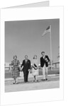 Group 4 high school students walking past american flag carrying textbooks by Anonymous