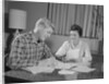 Couple man woman at table working on household accounts bills by Anonymous