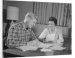 Couple man woman at table working on household accounts bills by Anonymous