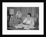 Couple man woman at table working on household accounts bills by Anonymous