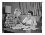 Couple man woman at table working on household accounts bills by Anonymous