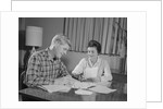 Couple man woman at table working on household accounts bills by Anonymous