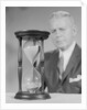 Elderly man soft focus behind hourglass by Anonymous
