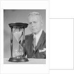Elderly man soft focus behind hourglass by Anonymous