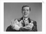 Smiling man holding money bags and bundles of cash by Anonymous