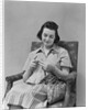 Brunette woman knitting sitting in armchair by Anonymous