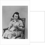 Brunette woman knitting sitting in armchair by Anonymous