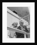Smiling mature couple at shipboard rail with binoculars by Anonymous