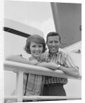 Portrait smiling couple standing by shipboard rail by Anonymous