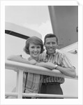 Portrait smiling couple standing by shipboard rail by Anonymous