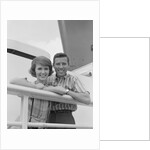 Portrait smiling couple standing by shipboard rail by Anonymous