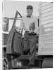 Delivery man stepping out of truck holding clipboard by Anonymous