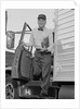 Delivery man stepping out of truck holding clipboard by Anonymous