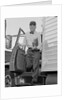 Delivery man stepping out of truck holding clipboard by Anonymous