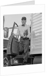 Delivery man stepping out of truck holding clipboard by Anonymous