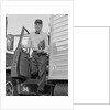 Delivery man stepping out of truck holding clipboard by Anonymous