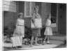 Mother and two daughters carrying shopping bags packages into house by Anonymous