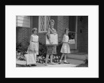 Mother and two daughters carrying shopping bags packages into house by Anonymous