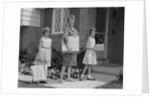 Mother and two daughters carrying shopping bags packages into house by Anonymous
