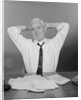 Smiling man working on family budget papers at desk by Anonymous