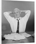 Smiling man working on family budget papers at desk by Anonymous