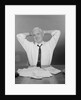 Smiling man working on family budget papers at desk by Anonymous