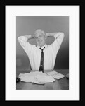 Smiling man working on family budget papers at desk by Anonymous