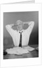 Smiling man working on family budget papers at desk by Anonymous