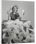 Woman holding eyeglasses and end of extremely long tape from office machine by Anonymous