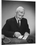 Man writing check from checkbook by Anonymous