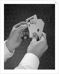 Male hands holding hand poker cards 4 aces and a king by Anonymous