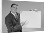 Smiling man pointing to blank poster by Anonymous