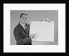 Smiling man pointing to blank poster by Anonymous