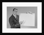 Smiling man pointing to blank poster by Anonymous