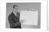 Smiling man pointing to blank poster by Anonymous
