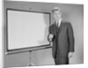 Man standing beside blank screen ready for presentation by Anonymous