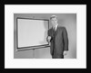 Man standing beside blank screen ready for presentation by Anonymous