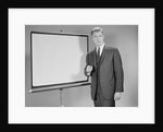 Man standing beside blank screen ready for presentation by Anonymous