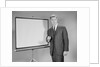 Man standing beside blank screen ready for presentation by Anonymous