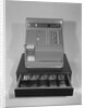 Cash register with money in the open till drawer by Anonymous