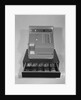 Cash register with money in the open till drawer by Anonymous
